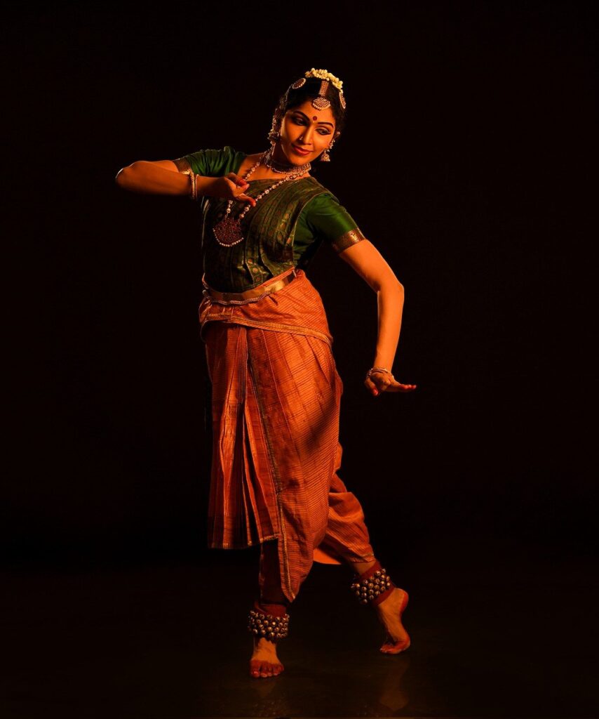 An Asian Traditional dancer in an orange dress with a red scarf and makeup  performing at the dance festival 19087229 Stock Photo at Vecteezy